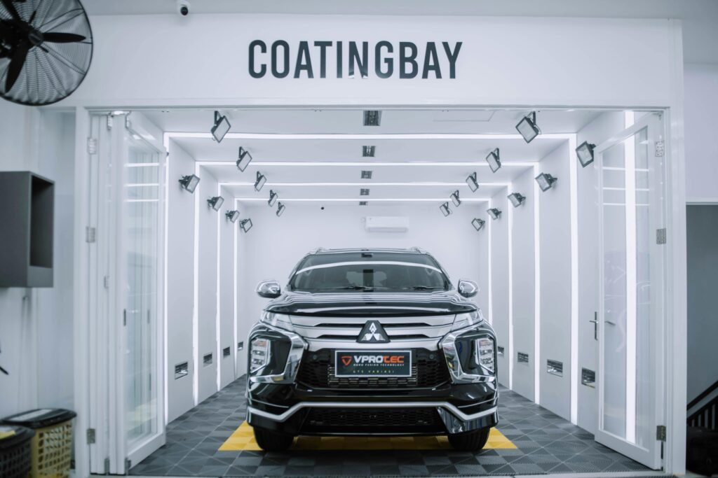 A sleek Mitsubishi SUV inside a modern automotive coating facility.