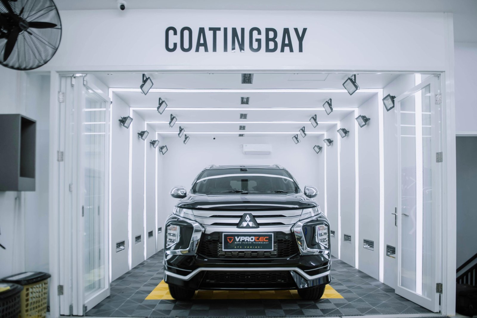 A sleek Mitsubishi SUV inside a modern automotive coating facility.