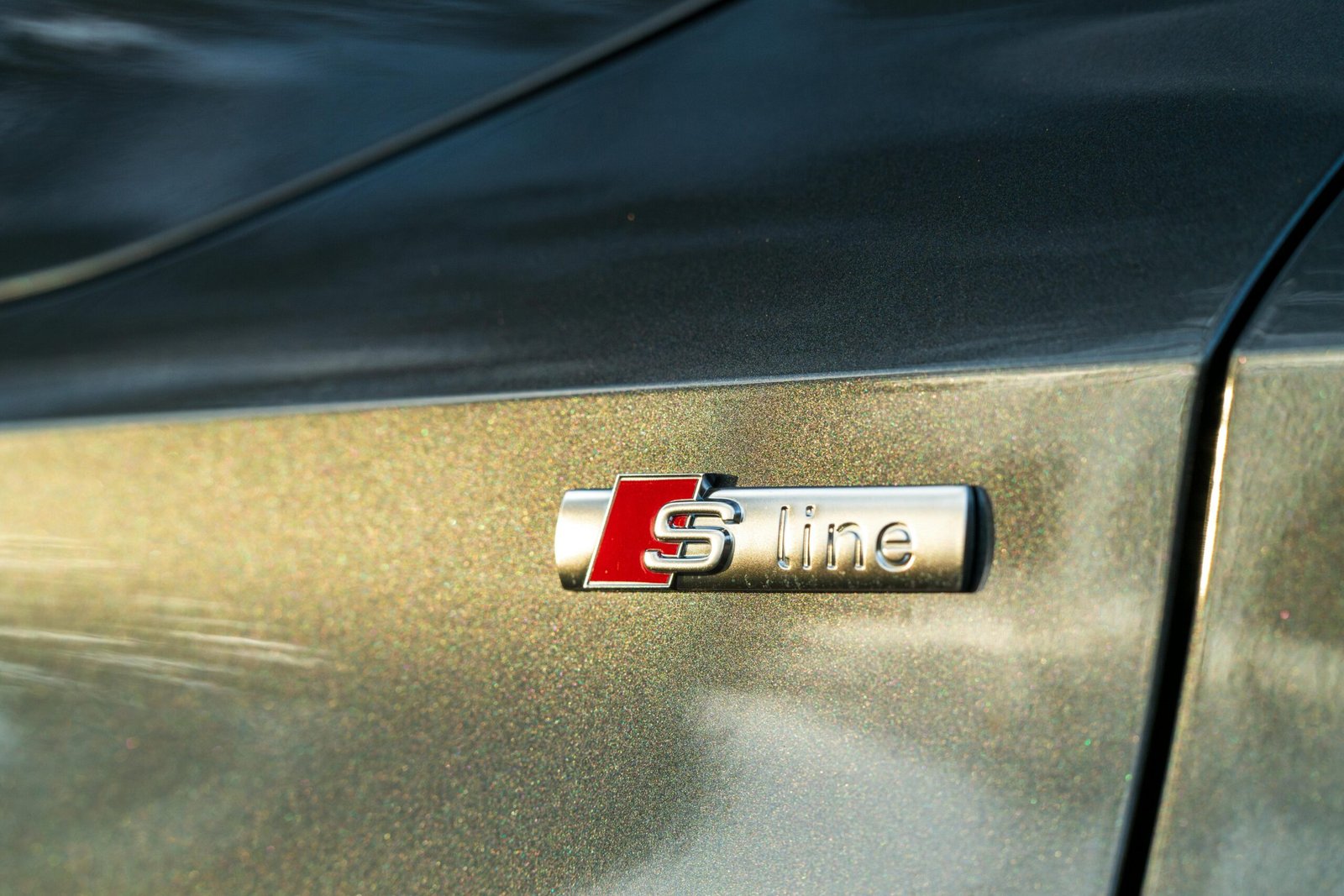 Detailed close-up of an S Line badge on a luxury gray vehicle, showcasing automotive design.